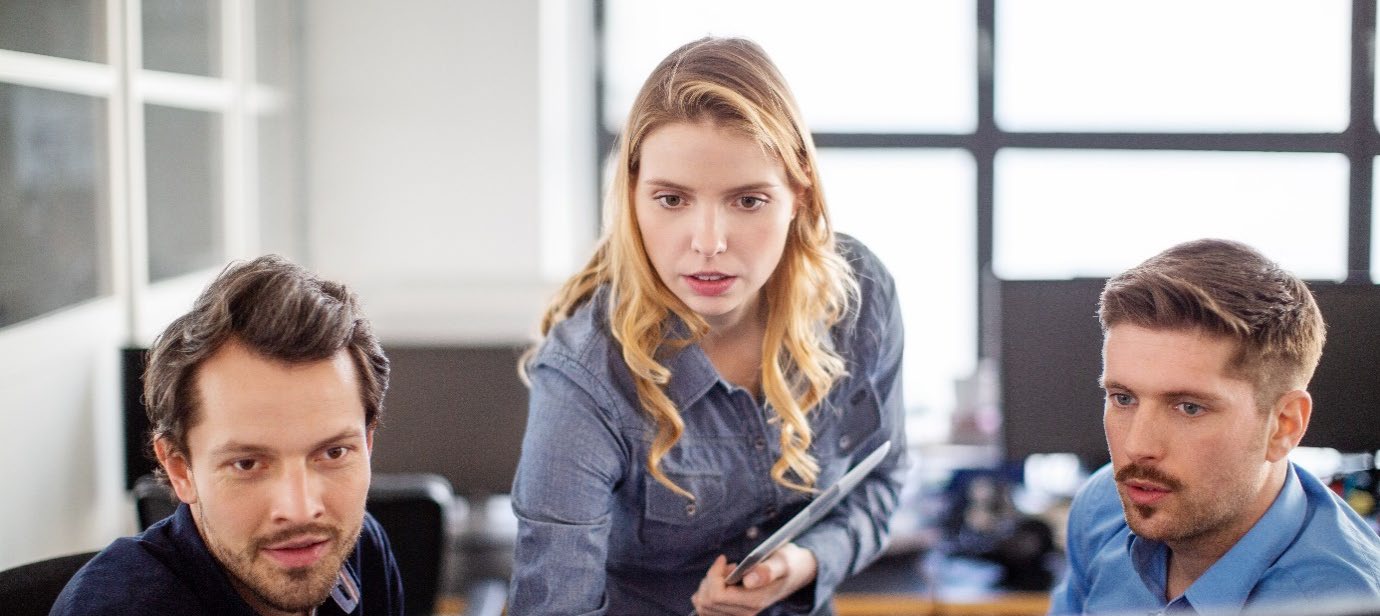 Drei Personen in einer Besprechung im Büro